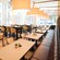 Un restaurante contemporáneo con ventanas de piso a techo, candelabros, mesas y sillas